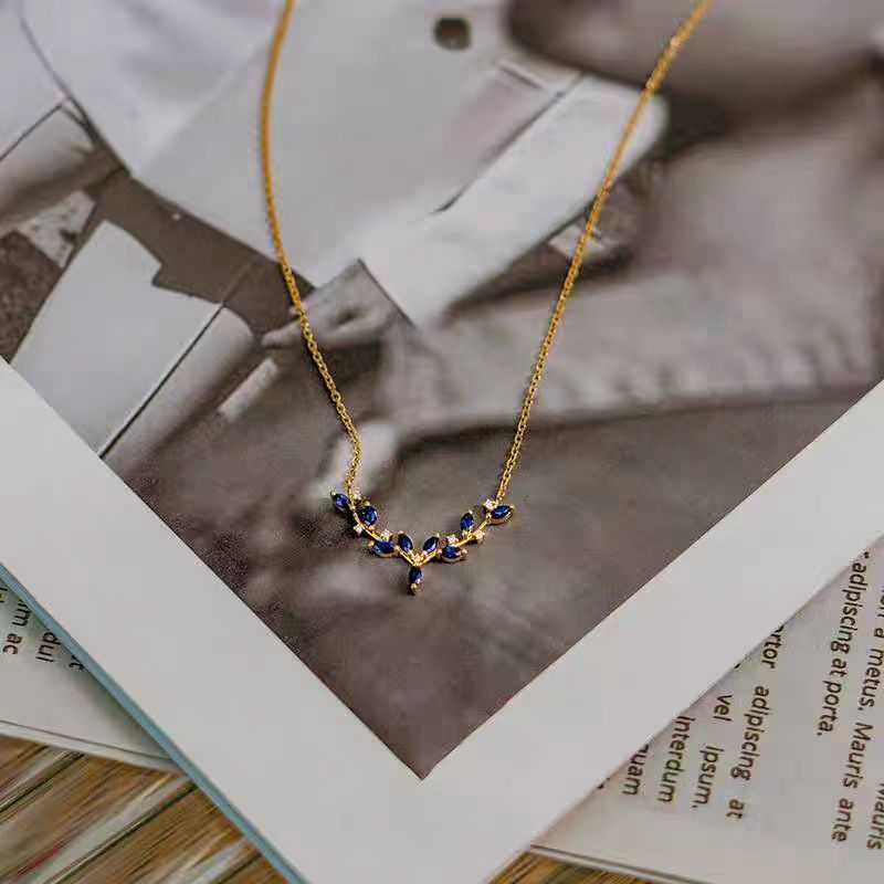 Gold necklace with blue stones on an open book