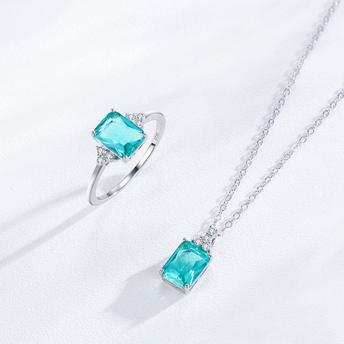 Jewelry set with ring and necklace featuring turquoise gemstones on a white background