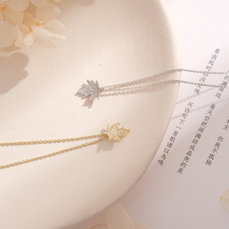 Two butterfly necklaces on a white surface with a soft focus background