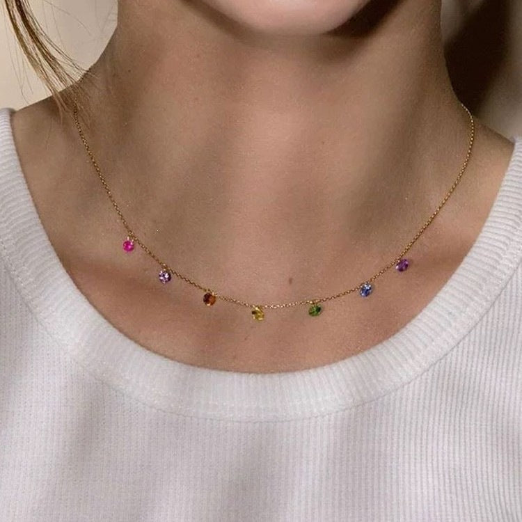 Necklace with colorful beads worn by a person against a neutral background