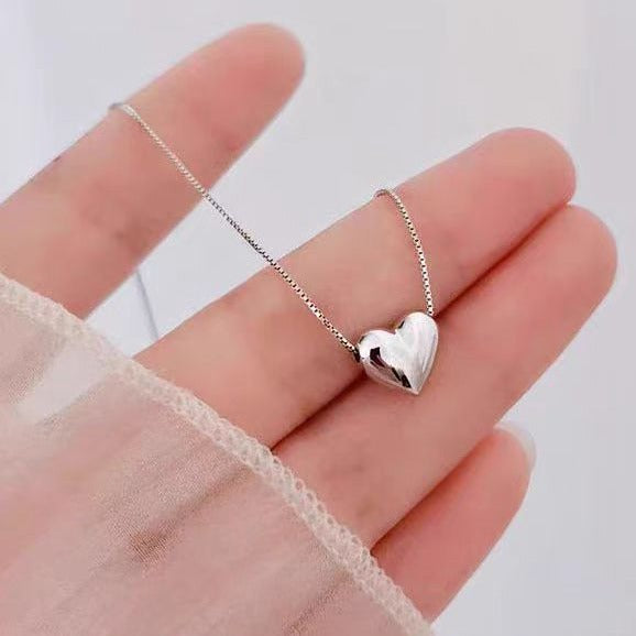 A delicate gold chain necklace featuring a butterfly pendant with blue and white enamel details, displayed on a light lavender background.