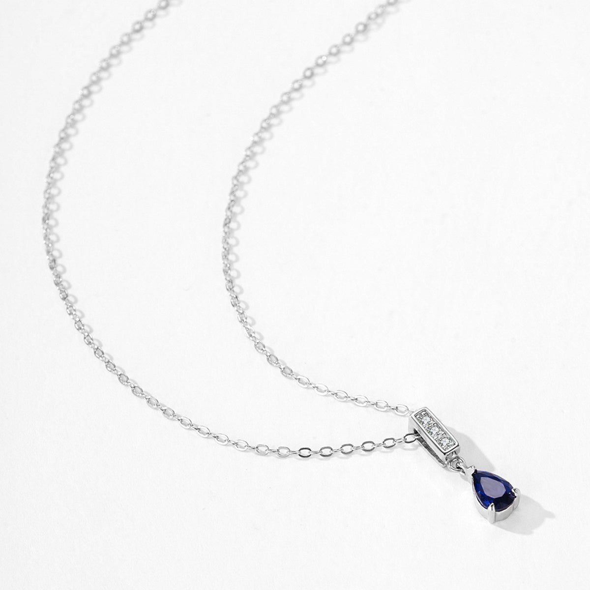A delicate gold double-strand bracelet with a small flower charm and a star-shaped crystal accent, shown worn on a person's wrist with their hand resting behind it.